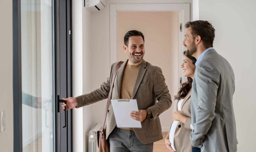 A young couple with a real-estate agent visiting an apartment fo