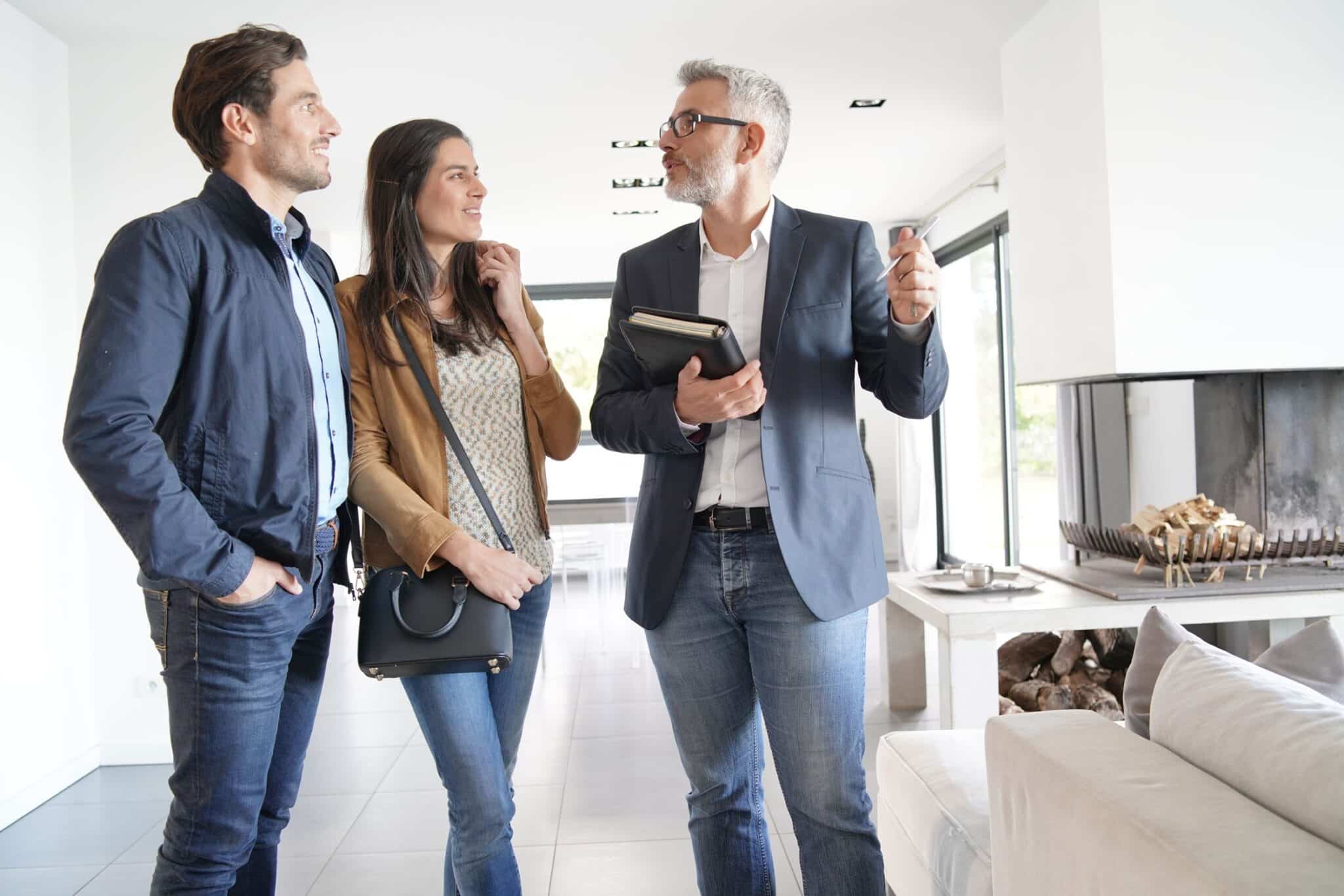 Couple with real-estate agent visiting modern house